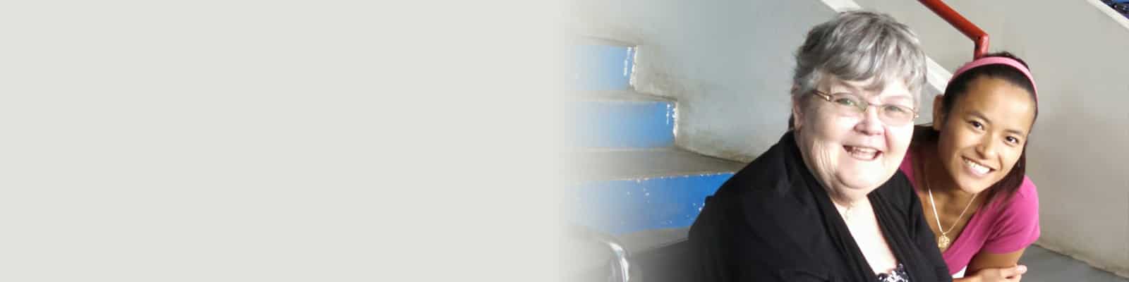 A caregiver sitting with a resident in a wheelchair at a remote activity