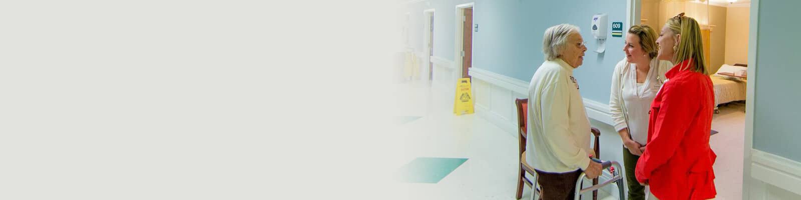 two staff members and a resident in the hallway of Richwood Nursing & Rehab