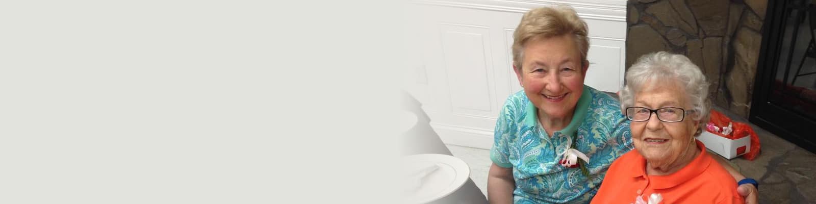 A resident and a caregiver sitting at a table